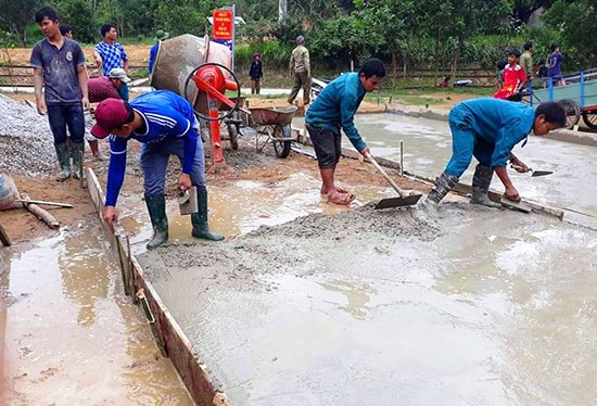 Các ĐVTN huyện Nam Giang giúp đồng bào địa phương bê tông hóa sân của nhà làng truyền thống, chuẩn bị đón tết. Ảnh: Đ.N