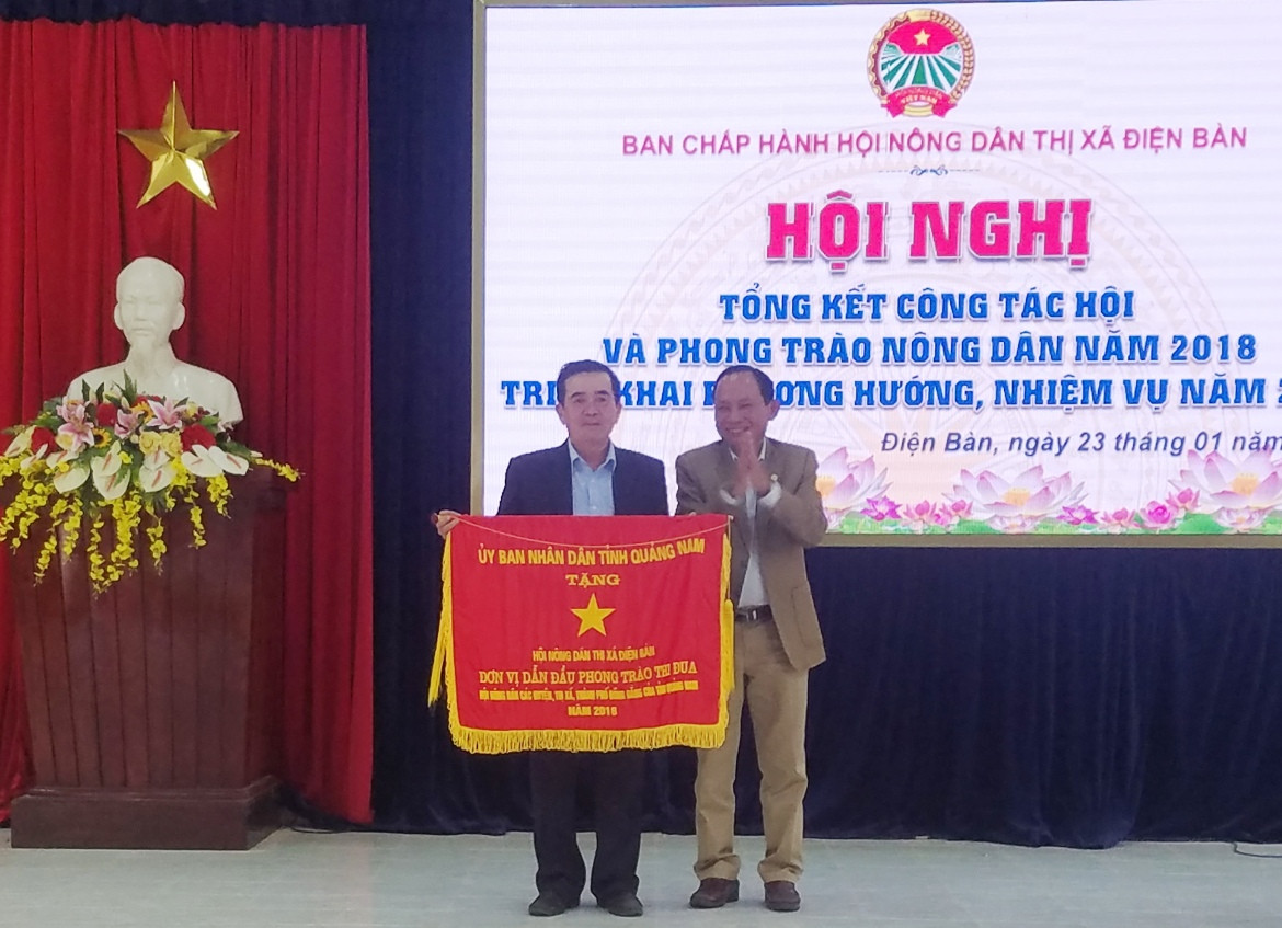 Ông Vũ Văn Thẩm - Chủ tịch Hội Nông dân tỉnh trao cờ thi đua của UBND tỉnh tặng cho Hội Nông dân Điện Bàn. Ảnh: Q.T