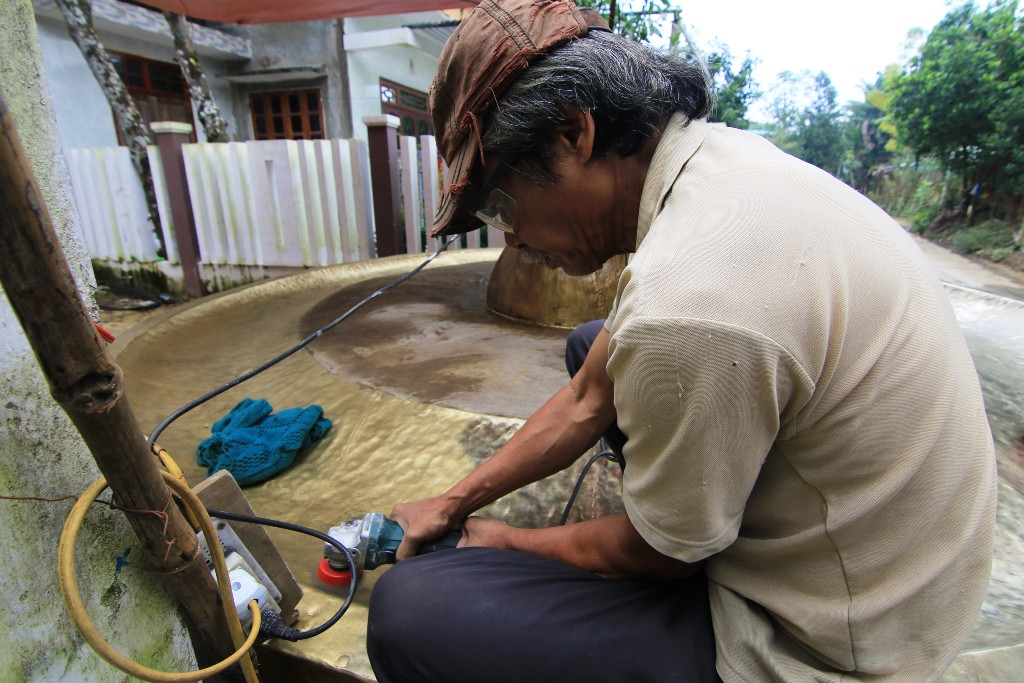 Công đoạn gia công hoàn thiện mô hình chiêng đồng. Ảnh: T.C