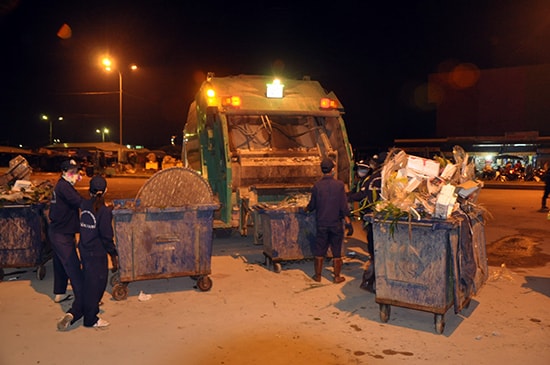 Công nhân môi trường đô thị thu dọn vệ sinh rác thải tại khu vực chợ Tam Kỳ vào dịp tết năm 2018. Ảnh: TRẦN HỮU.