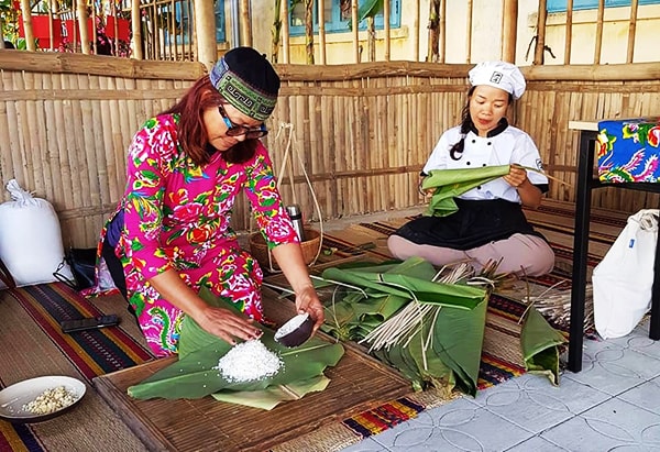 Các bà mẹ Tây học gói bánh. Ảnh: MINH HẢI