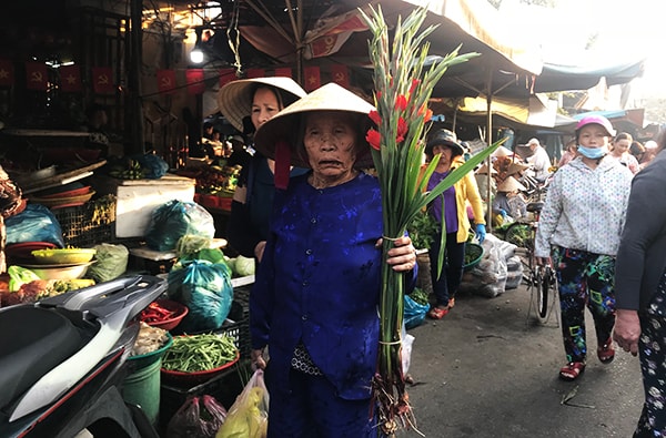 Các cụ già dù đến chợ chỉ mua một bó hoa cũng là vui với phiên chợ đầu năm. Ảnh: MINH HẢI