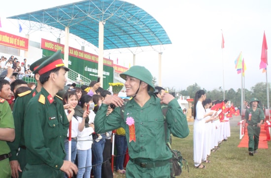 Nụ cười của một tân binh với gia đình, bạn bè trước phút lên xe đến đơn vị. Ảnh: D.L