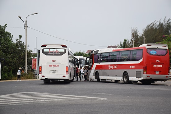 Xe chở khách du lịch thường xuyên đậu, đỗ rồi trả khách ngay trong khu vực ngã tư đèn xanh đèn đỏ cầu Cửa Đại (xã Cẩm Thanh, TP.Hội An) khiến giao thông bị ùn tắc. Ảnh: T.THẮNG