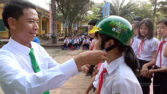 Công ty taxi Mai Linh tặng mũ bảo hiểm cho học sinh có hoàn cảnh khó khăn. Ảnh: PHAN SƠN