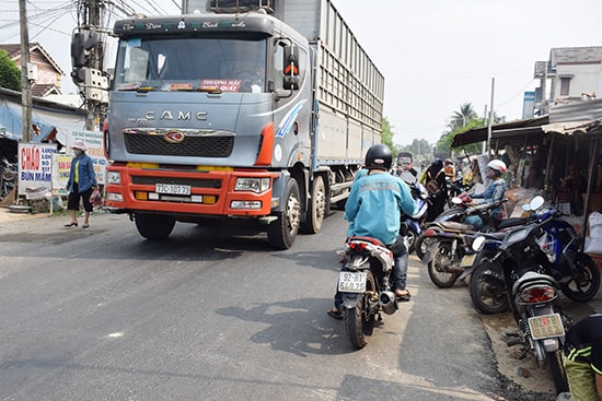 Người dân thường xuyên lấn chiếm lòng đường tuyến QL14E, đoạn qua trước chợ Bình Quý (xã Bình Quý, Thăng Bình) khiến việc lưu thông của các phương tiện gặp khó khăn.Ảnh: THANH THẮNG