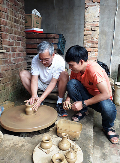Thợ trẻ Lê Văn Nhật đang cùng du khách trải nghiệm chuốt gốm tại nhà. Ảnh: Đ.H
