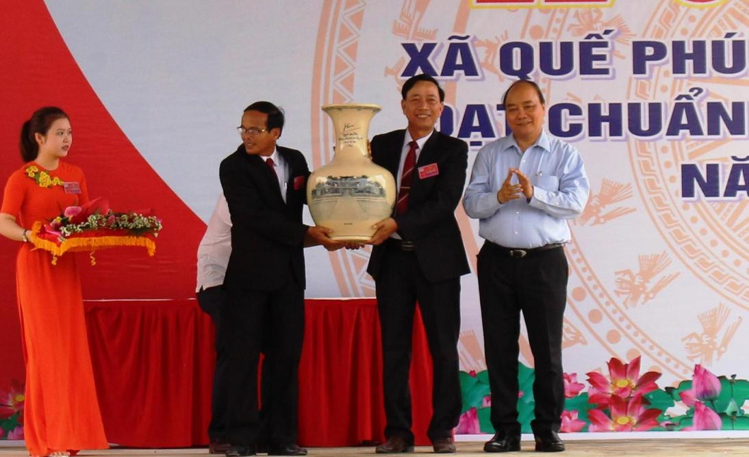 Thủ tướng Chính phủ Nguyễn Xuân Phúc tặng quà lưu niệm cho lãnh đạo xã Quế Phú. Ảnh: VĂN SỰ