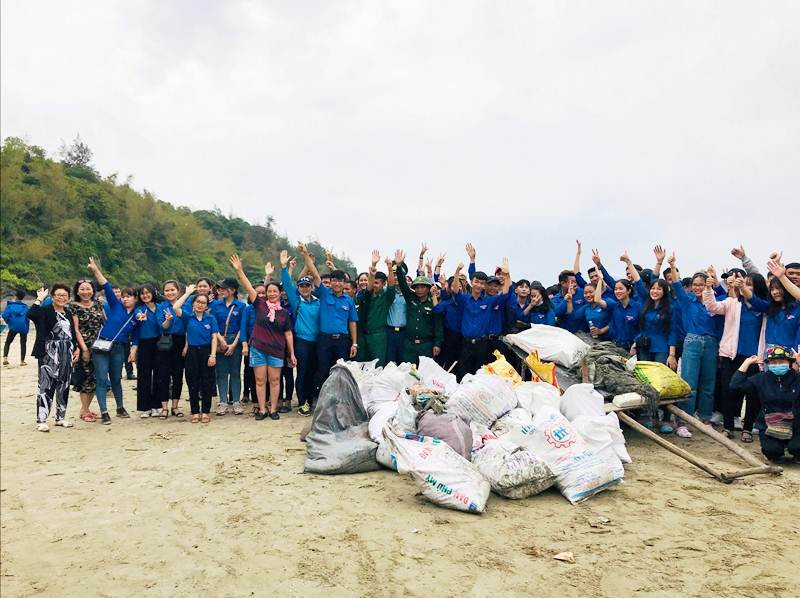 Lực lượng đoàn viên thanh niên và du khách cùng nhau tham gia dọn rác, làm sạch bãi biển. Ảnh: M.H