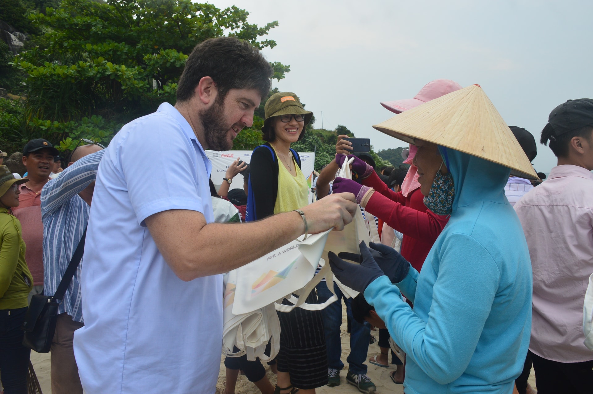 Ông Michael Croft - Trưởng đại diện Văn phòng UNESCO tại Việt Nam trao túi sinh thái cho người dân Cù Lao Chàm thu gom rác vào chiều 30.3. Ảnh: T.H