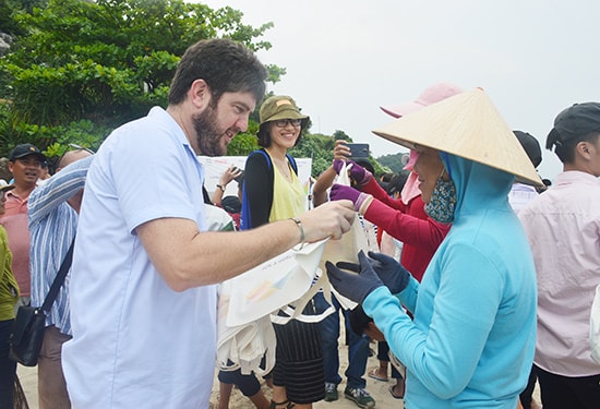 Trưởng đại diện Văn phòng UNESCO tại Việt Nam trao túi sinh thái cho người dân trên đảo dọn dẹp rác. Ảnh: T.H