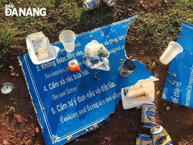Rác được xả ngay trên tấm bảng khuyến cáo giữ gìn vệ sinh môi trường tại bán đảo Sơn Trà. 
