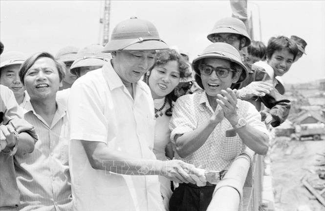Ngày 20/6/1985, Phó Chủ tịch Hội đồng Bộ trưởng, kiêm Bộ trưởng Bộ Giao thông vận tải Đồng Sĩ Nguyên đến kiểm tra công trình xây dựng cầu Chương Dương và trực tiếp quét sơn lan can cuối cùng trước lễ thông cầu, 30-6-1985. Ảnh: Cao Phong/TTXVN.