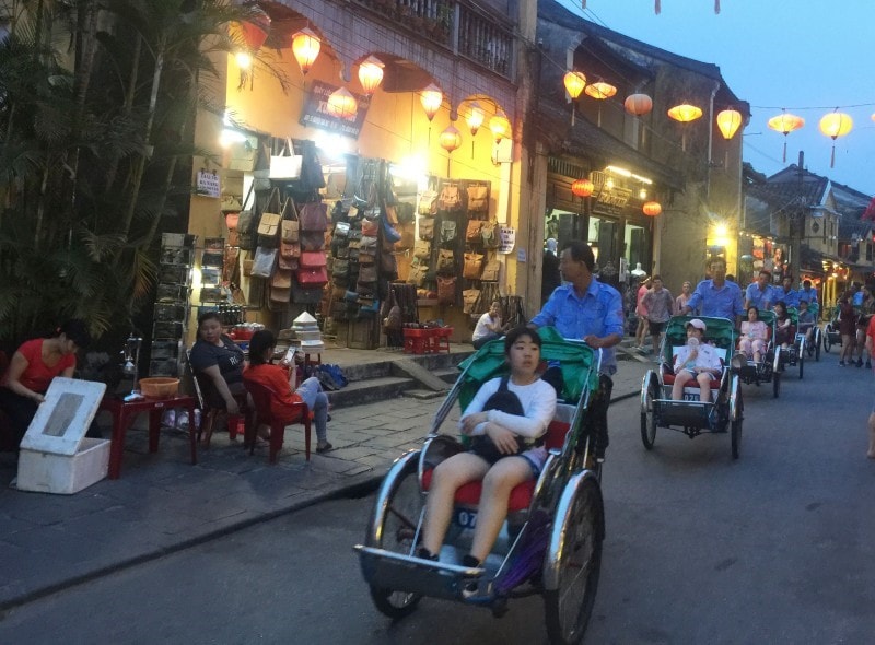 Visitors like enjoying Hoi An night with colourful lanterns on pedicabs.