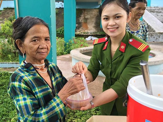 Chiến sĩ Công an huyện Đông Giang trao suất cháo từ thiện cho người bệnh. Ảnh: Đ.N