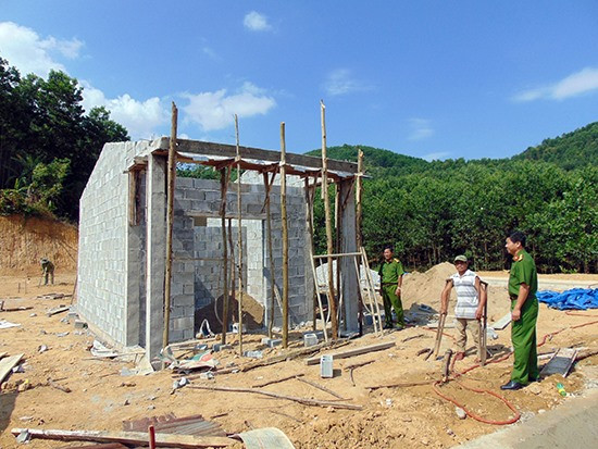 Anh Hồ Văn Thắng cùng cán bộ Công an huyện Phước Sơn bên căn nhà tình nghĩa đang được xây dựng. Ảnh: T.N