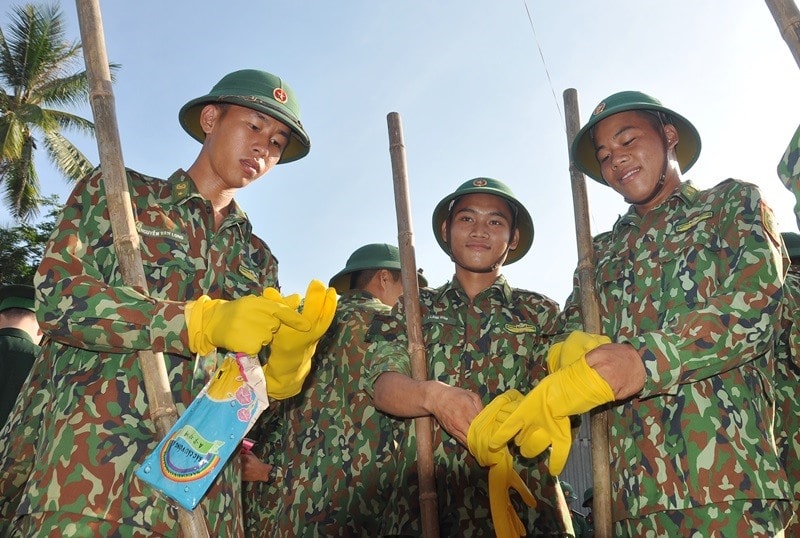 Chiến sĩ trẻ Bộ đội Biên phòng tỉnh chuẩn bị dụng cụ ra quân dọn vệ sinh môi trường. Ảnh: VINH ANH