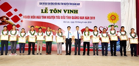 Lãnh đạo tỉnh đeo vòng nguyệt quế, trao bằng công nhận tôn vinh người hiến máu tình nguyện tiêu biểu. Ảnh: VINH ANH