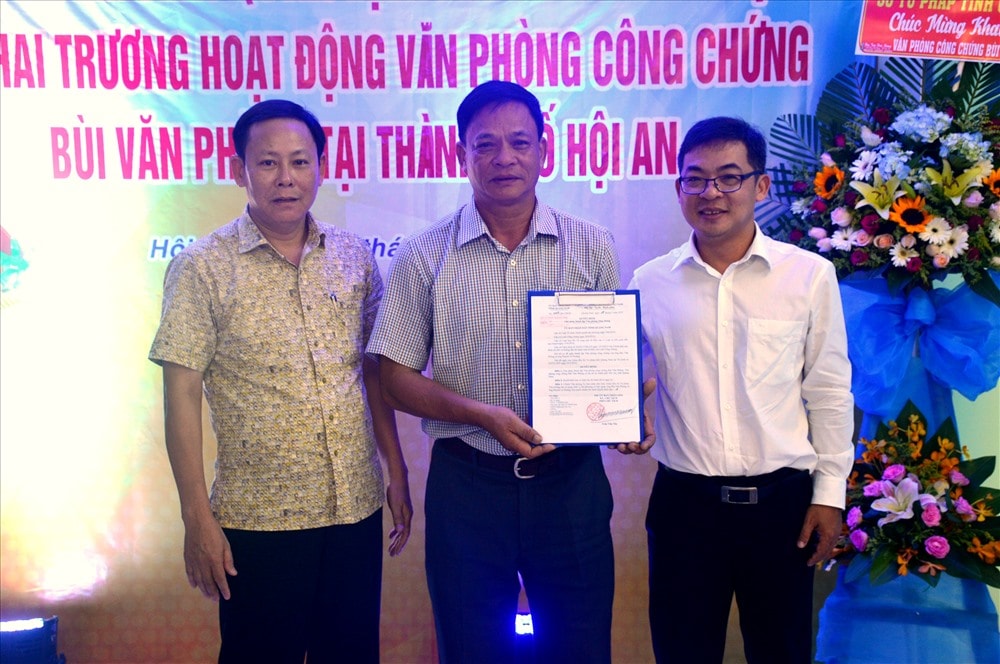 Ông Đặng Văn Đào - Giám đốc Sở Tư pháp (trái) trao quyết định của UBND tỉnh cho lãnh đạo Văn phòng công chứng Bùi Văn Phòng. Ảnh: Q.T