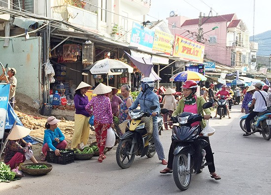 Chợ Trung Phước quá tải, người dân đưa hàng hóa ra đường buôn bán. Ảnh: PHAN VINH