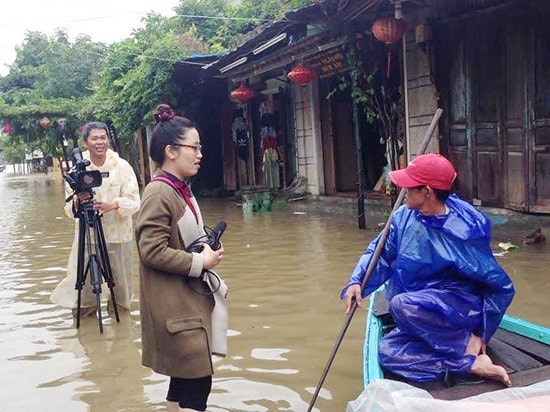 Tác nghiệp trong lũ tại Hội An. Ảnh: TẤN CHÂU