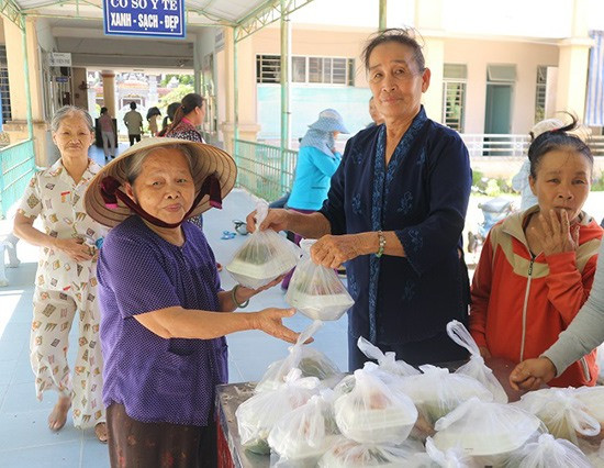 Chị Hoa phát cơm cho bệnh nhân tại Trung tâm Y tế huyện Duy Xuyên. Ảnh: T.MAI