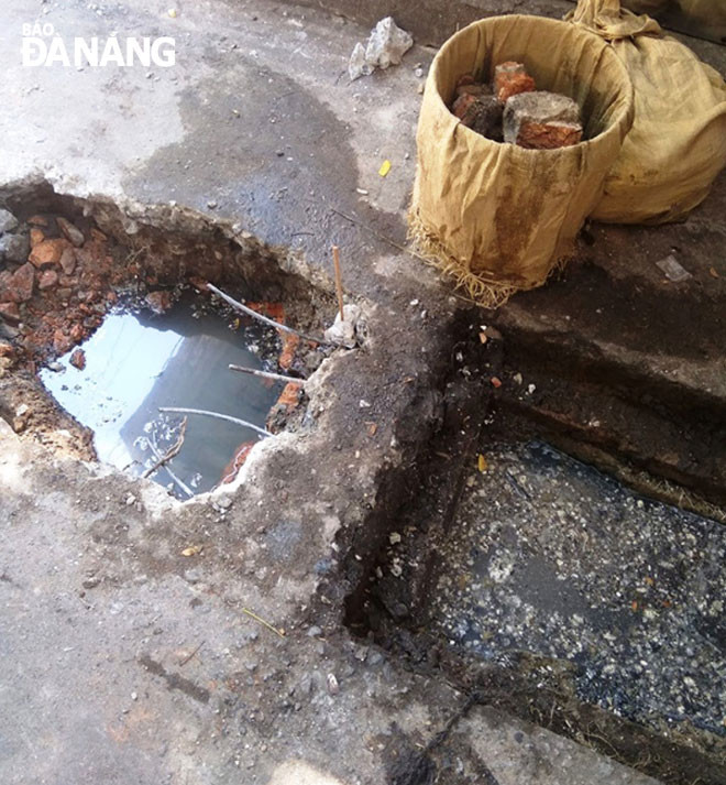 Người dân sống tại kiệt 25 Trần Quốc Toản than phiền tình trạng nước cổng lộ thiên, không rút được. Ảnh: Tiểu Yến