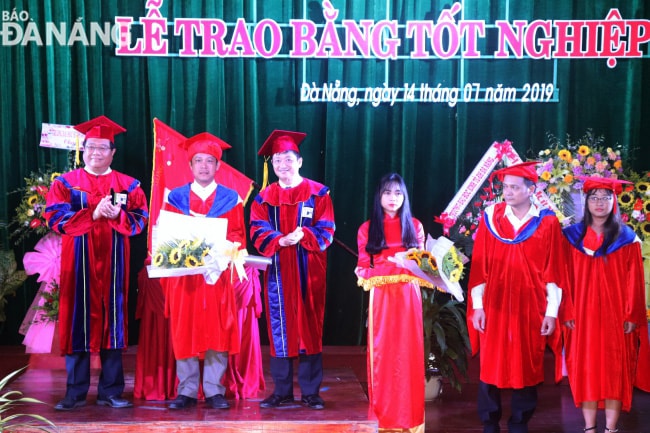 Phó Chủ tịch thường trực UBND thành phố Đặng Việt Dũng trao bằng cho các tân tiến sĩ.