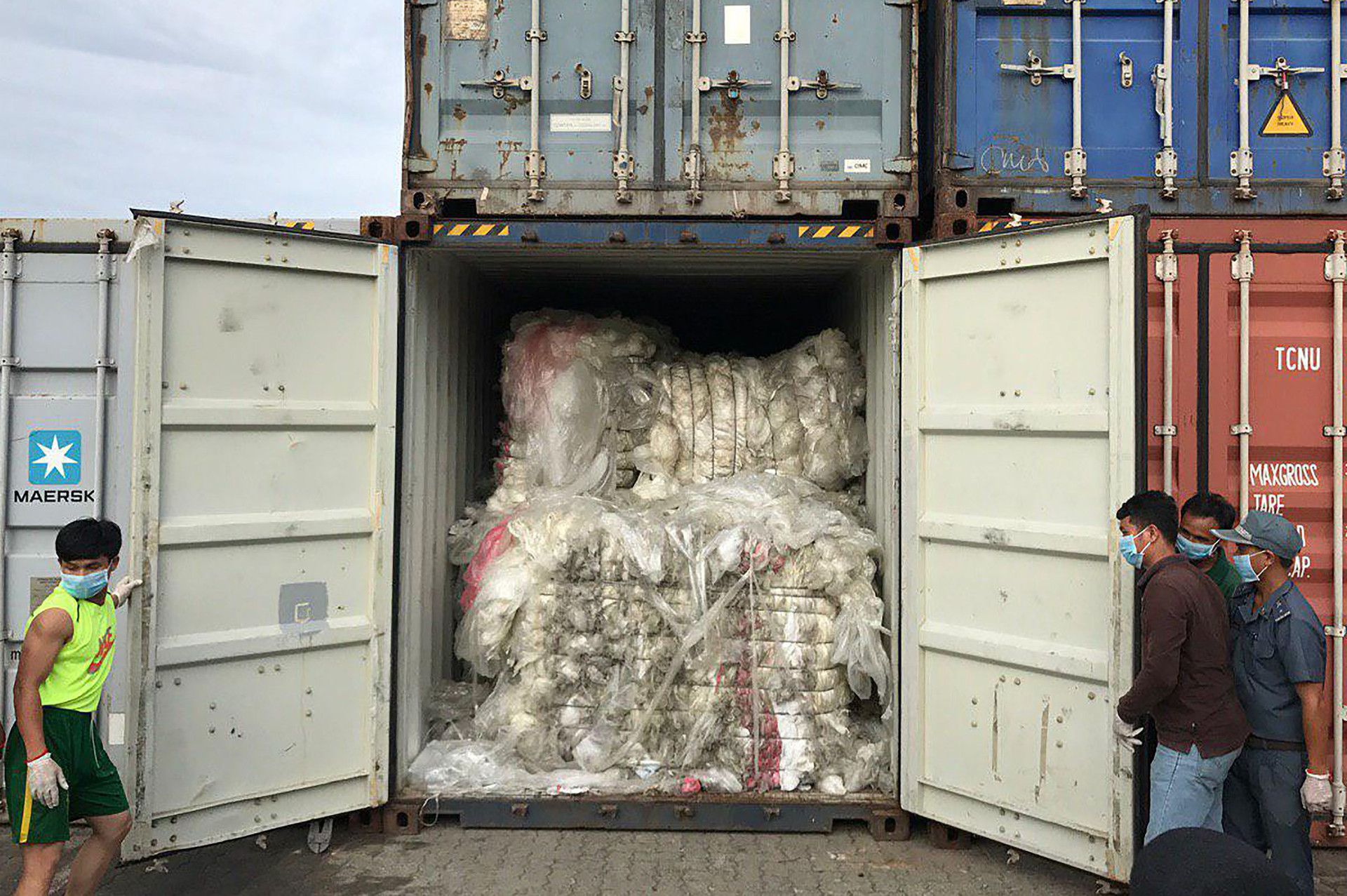 Các công nhân mở một container chứa rác thải nhựa sau khi lô hàng đến cảng Sihanoukville. Ảnh: AFP