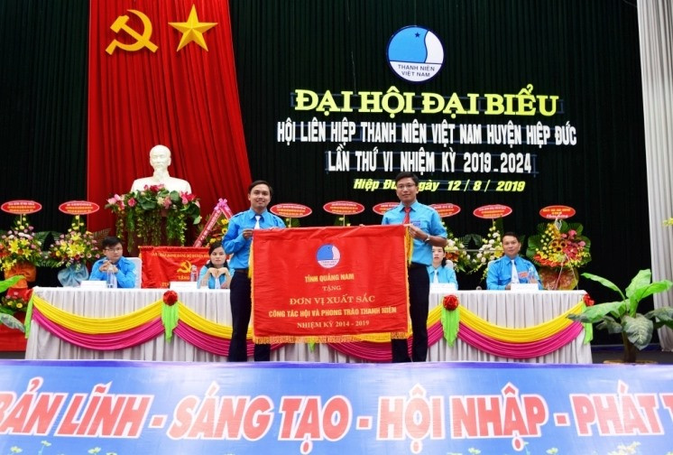 Tặng Cờ thi đua xuất sắc trong công tác hội và phong trào thanh niên cho Hội LHTN Việt Nam huyện Hiệp Đức. Ảnh: THÁI CƯỜNG