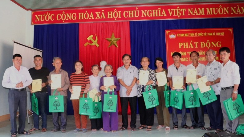 Ủy ban MTTQ Việt Nam xã Tam Hòa tặng túi thân thiện môi trường cho các hộ dân. Ảnh: THÁI CƯỜNG