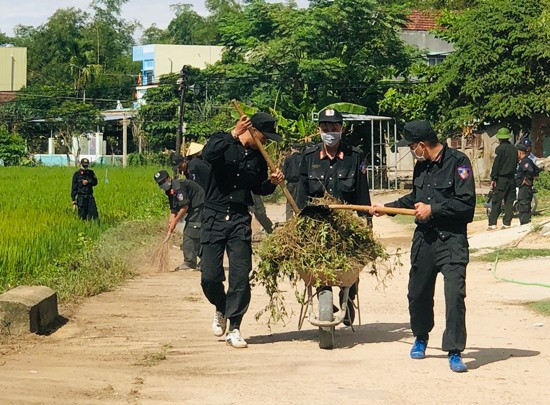 Chiến sĩ cảnh sát cơ động dọn dẹp các tuyến đường giao thông nông thôn tại xã Tam An. Ảnh: PHAN VINH