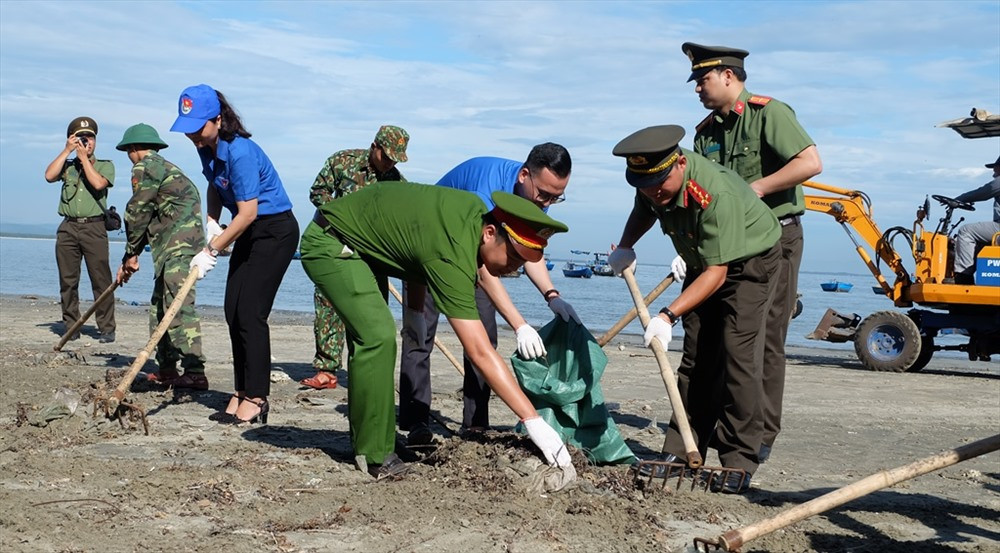 Lực lượng công an, bộ đội, ĐVTN địa phương tham gia dọn rác tại bãi biển. Ảnh: M.L