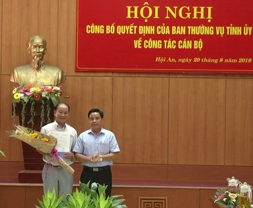 Phó Bí thư Tỉnh ủy Lê Văn Dũng trao quyết định và tặng hoa chúc mừng đồng chí Trần Ánh. Ảnh: hoian.gov.vn