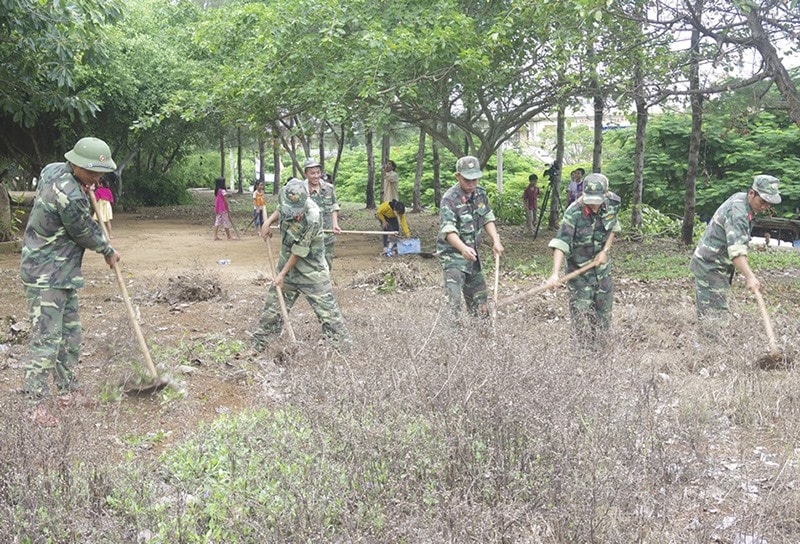 Ban CHQS huyện Lý Sơn giúp Trường Tiểu học xã An Vĩnh dọn vệ sinh môi trường. Ảnh: Đ.N