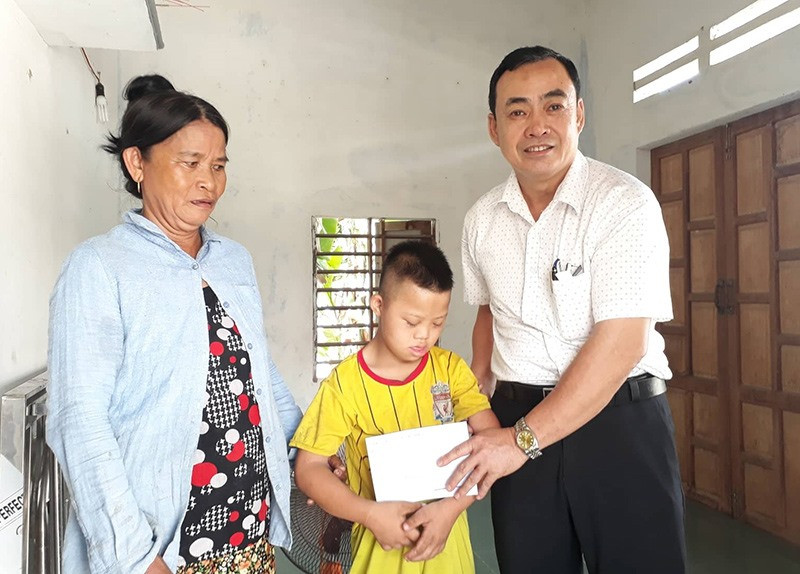 Lãnh đạo huyện Quế Sơn thăm, tặng quà cho trẻ em có hoàn cảnh đặc biệt khó khăn. Ảnh: T.P