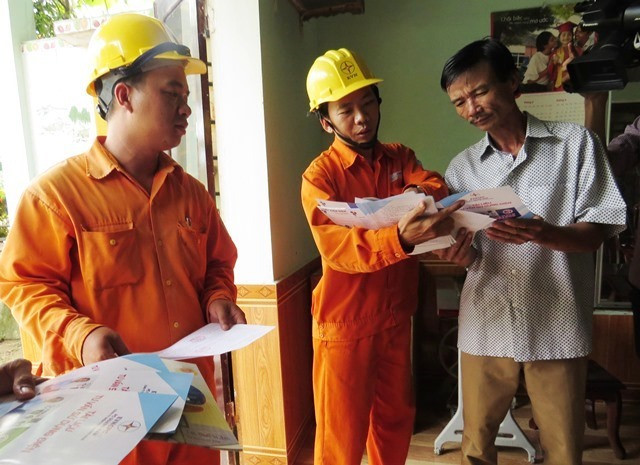 Nhân viên Điện lực Đại Lộc tuyên truyền tiết kiệm điện và an toàn về điện đến các hộ gia đình. Ảnh: HOÀNG LIÊN