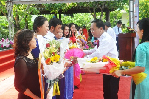 Chủ tịch UBND TP.Tam Kỳ Nguyễn Hồng Quang chúc mừng các phó giáo sư, tiến sĩ được vinh danh. Ảnh: X.P