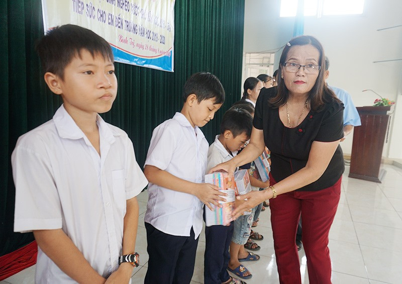 Bà Nguyễn Thị Kiều - Chủ tịch Hội LHPN xã Bình Trị trao quà cho học sinh nhân dịp năm học mới 2019-2020. Ảnh: Biên Tân