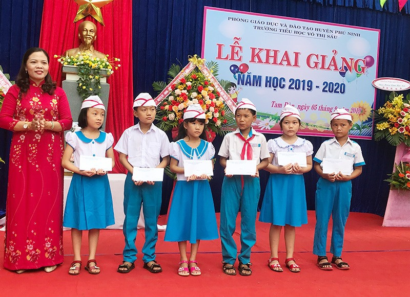 Lãnh đạo Phòng GD-ĐT huyện Phú Ninh trao quà cho học sinh vượt khó Trường Tiểu học Võ Thị Sáu. Ảnh: C.N