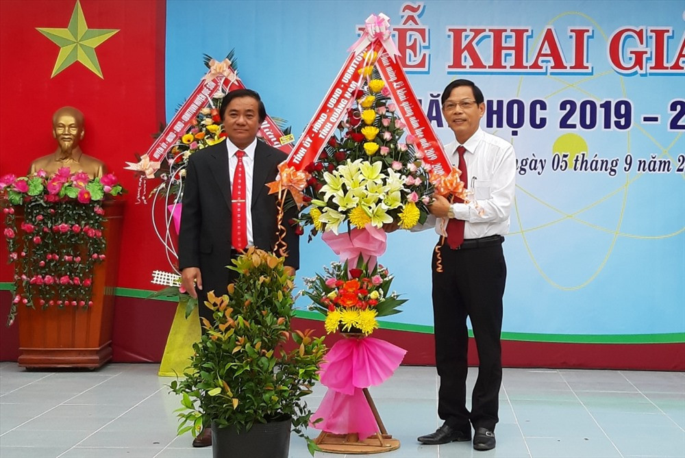 Trưởng ban Tổ chức Tỉnh ủy Nguyễn Chín (bìa phải) tặng hoa chúc mừng Trường THPT Nguyễn Văn Cừ. Ảnh: VĂN SỰ