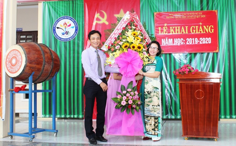 Lãnh đạo huyện Phú Ninh tặng hoa chúc mừng Trường THCS Lê Quý Đôn nhân lễ khai giảng năm học mới. Ảnh: H.C
