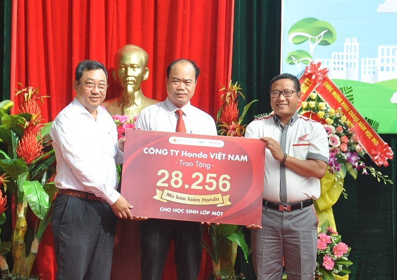 Ông Lê Văn Sinh - Giám đốc Sở GTVT (ngoài cùng bên trái) tiếp nhận bảng tượng trưng trao tặng 28.256 MBH cho học sinh lớp 1 tại Quảng Nam. Ảnh: V.ANH