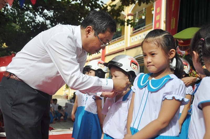 Ông Lê Văn Sinh tặng MBH cho học sinh Trường Tiểu học Trần Quốc Toản. Ảnh: V.ANH