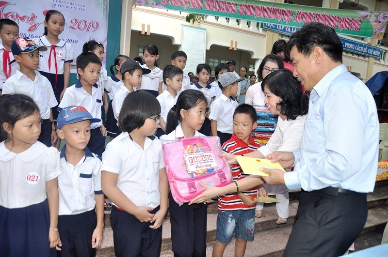 Phó Bí thư Thường trực Tỉnh ủy Lê Văn Dũng tặng quà cho các em có hoàn cảnh khó khăn. Ảnh: VINH ANH