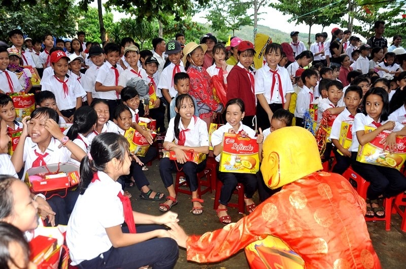 Các em học sinh vui vẻ trêu đùa cùng ông địa. Ảnh: VINH ANH