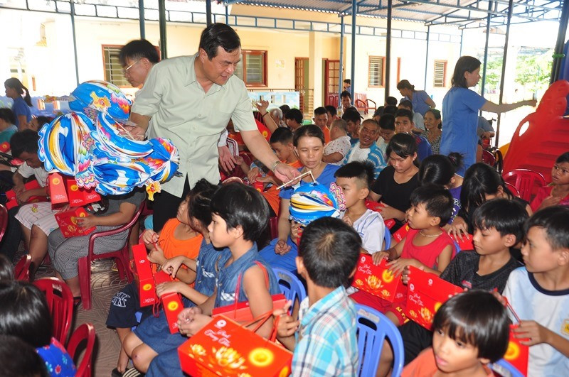 Bí thư Tỉnh ủy Phan Việt Cường phát đèn trung thu cho trẻ em Làng Hòa Bình. Ảnh: VINH ANH