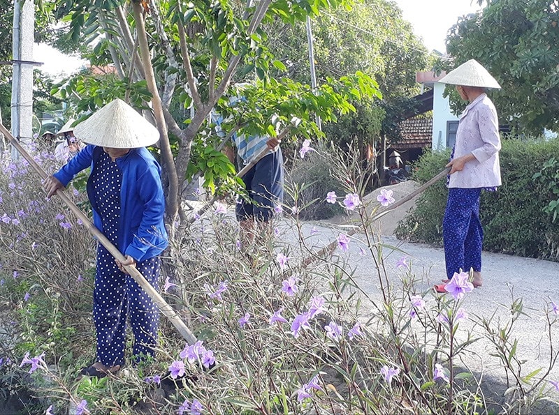 Hội viên phụ nữ xã Quế Cường (Quế Sơn) chăm sóc đường hoa. Ảnh: T.P