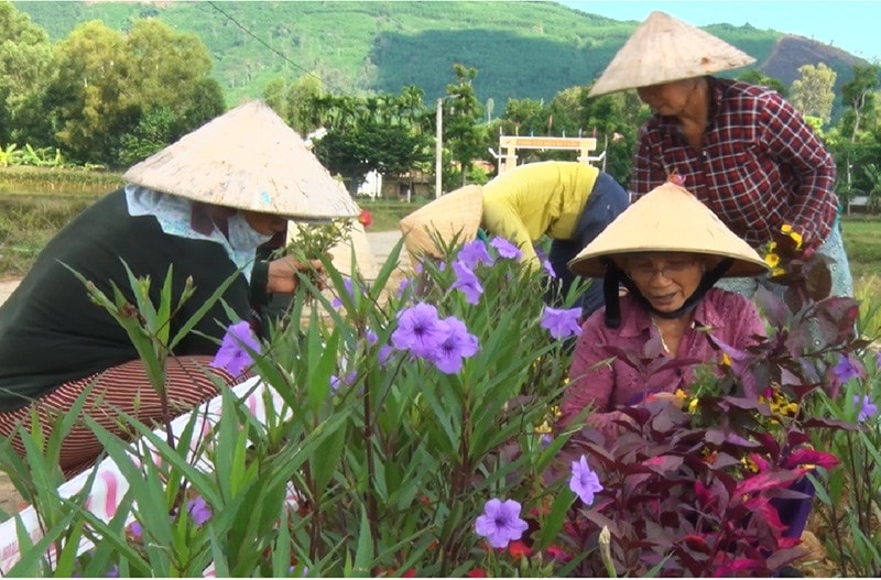 Phụ nữ thôn Tây Lộc chăm sóc tuyến đường hoa. Ảnh: Q.VƯƠNG