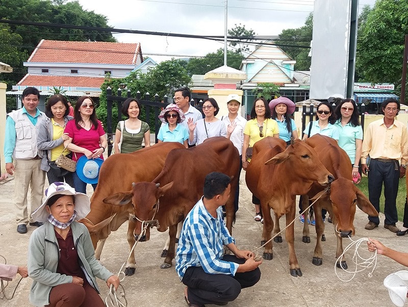 Anh Nguyễn Khắc Kiều (đứng, ngoài cùng bìa trái) trong chương trình trao bò sinh kế cho hộ nghèo tại xã Bình Lãnh, Thăng Bình năm 2016. Ảnh: X.T